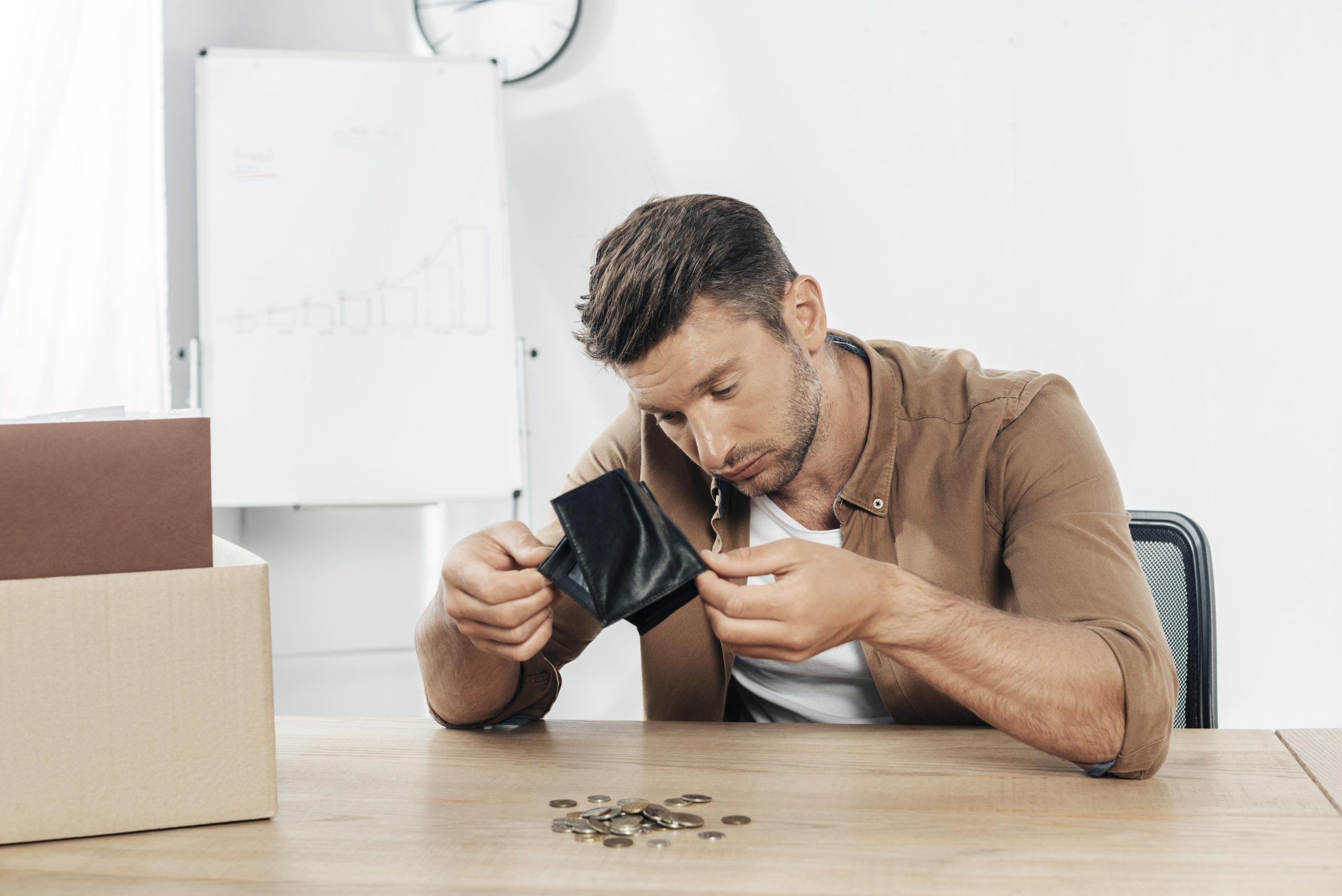 Worried small business owner checking empty wallet due to unexpected importing costs